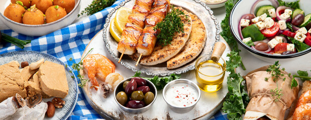 Greek cuisine dishes on neutral background.