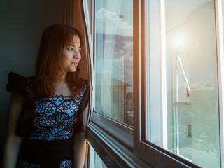 Image of business woman smiling face asian standing at the window at the office.
