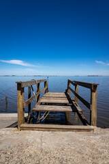 old and broken wooden pier at the edge of the lake.