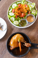 Roasted chicken with Japanese salad on wooden brown table and background.