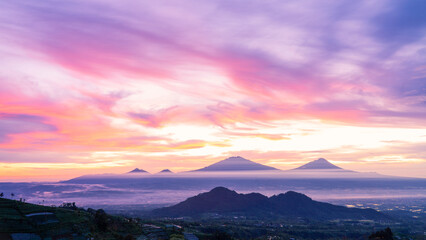 Beautiful dramatic reddish orange sunrise sky with mountain range - Merapi Volcano, Merbabu, Telomoyo and Andong Mountain