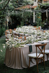 a beautiful wedding decoration arrangement. Table settings. Table Decoration for intimate private party outdoors with fairy light and white flowers. 
