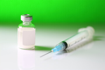 Medical vial of a neon green substance and hypodermic needle. Concept of drug addiction or toxic substance.