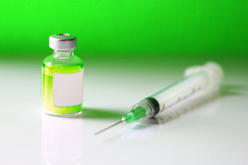 Medical vial of a neon green substance and hypodremic needle. Concept of addiction. Concept of harmful or poisonous substance.