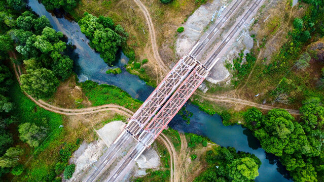 railway bridge over a small river close-up view from above, bright colorful photo