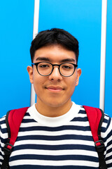 Portrait of teen latino hispanic male high school student looking at camera wearing glasses and...