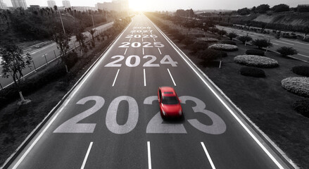 Highway with single red car, and number 2023, 2024 to 2028 on the road