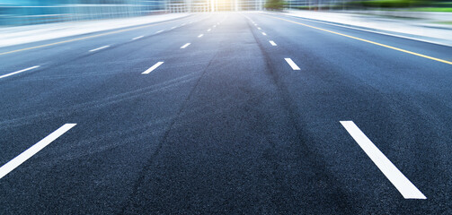 Black asphalt road with white dividing lines in blurred motion