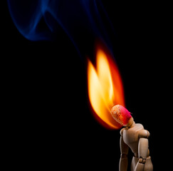 Depressed Wooden Doll With Head on Fire Isolated on Black Background and Low Light Environment