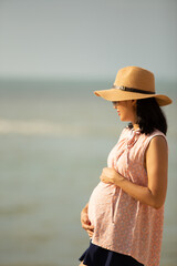 side view of beautiful pregnant woman on the beach