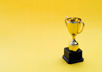 Golden trophy on yellow background
