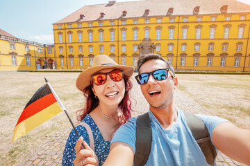 Two happy Travel bloggers takes selfie photos with german flag on the smartphone of the Osnabruck...