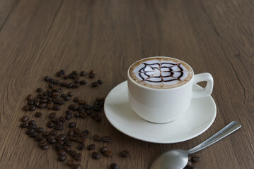 Coffee in a mug  and beans on a wood grain background