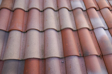 Red roof tiles ceramic shingles on house building as background