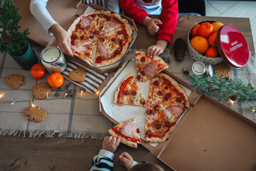 Happy children eat pizza, christmas dinner. The concept of a culinary New Year's master class