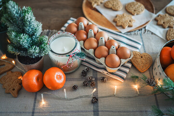 Ingredients for making Christmas cookies. Candle, eggs, tangerines, New Year's decor