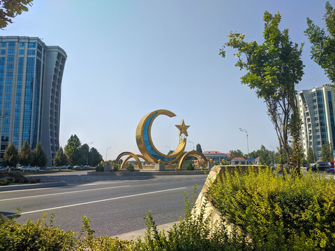 Argun, Chechnya, Russia - August 17, 2022: View of the stela in the form of a crescent with a star and high-rise buildings of the Argun City complex