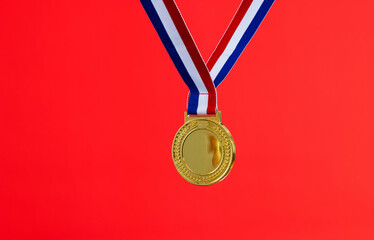 Blank gold medal on red background