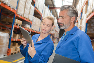 2 warehouse workers using a tablet