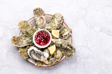 Fresh oysters with sauce and lemons
