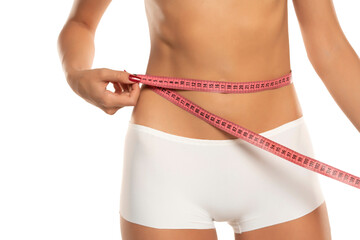 Woman measuring her waistline on a white background. Perfect Slim Body