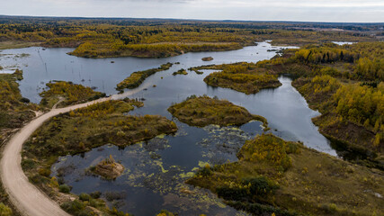 panoramic view from a drone of a network of lakes and islands with a yellow forest against the backdrop of autumn colors