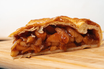 Apple pie on a wooden board cut into pieces