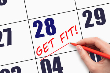 28th day of the month. Hand writing text GET FIT and drawing a line on calendar date. Save the...