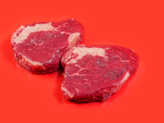 Rib eye steak with high amount of marbling on red surface. Premium beef. High quality meat. Food supply and butcher craft.