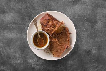 Roast beef, beef stew, cut boiled piece of beef with sauce on a plate.