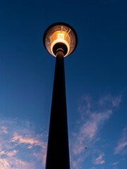 Fototapeta na wymiar Modern powerful LED light in old style lantern against blue cloudy sunset sky. City and town illumination tool. Energy saving light.