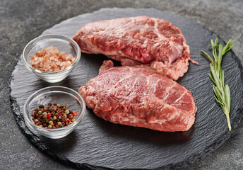 Raw fresh pork cheeks with salt and pepper. Preparing Meat for Dinner.