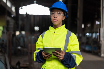 Portrait of woman engineer worker working with digital tablet at the industry factory area. Female...