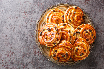 French traditional pastries Pains aux raisins closeup in the plate on the table. Horizontal top...