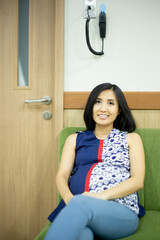 pregnant woman sitting and waiting for turn to check her baby to the doctor