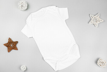 Mockup of a white infant cotton bodysuit  with  baby accessories.Gender neutral bodysuit template.