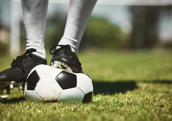 Soccer player feet, deflated soccer ball and sports, competition game and training on grass field,...