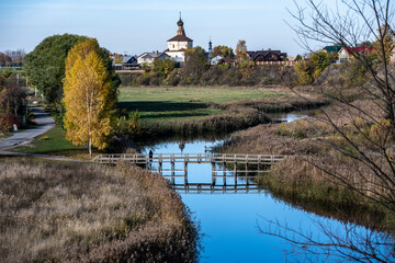 an old church against the backdrop of a river and an autumn sunny landscape