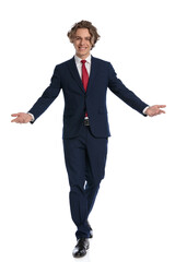 young guy with curly hair wearing suit, opening arms and welcoming