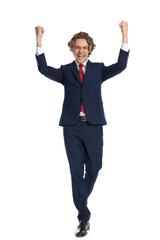 man with curly hair holding fists above head and celebrating victory