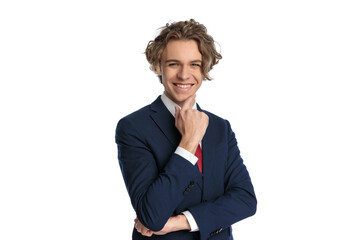 happy young businessman with curly hair touching chin and smiling