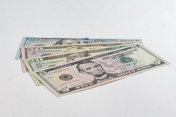 5, 20, 50, 100 dollars banknotes at different angles. Close up of dollars on white background.