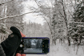 Mobile phone in hand. Winter background 