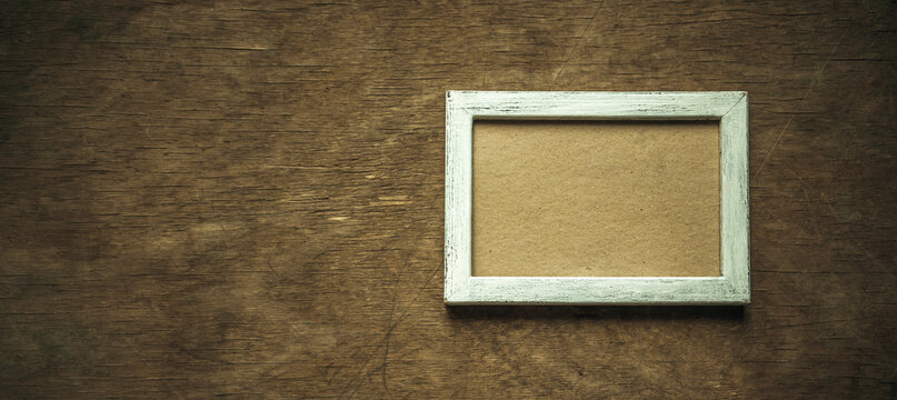 Horizontal wooden antique frame in white on a wooden background. Background for vintage style photo collage.