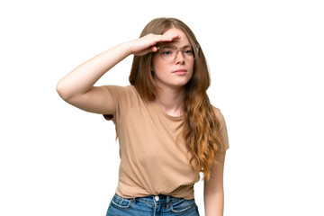 Young pretty woman over isolated background looking far away with hand to look something