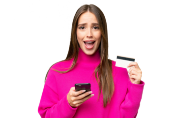 Young beautiful caucasian woman over isolated background buying with the mobile and holding a credit card with surprised expression