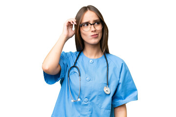 Young nurse caucasian woman over isolated background having doubts and with confuse face expression