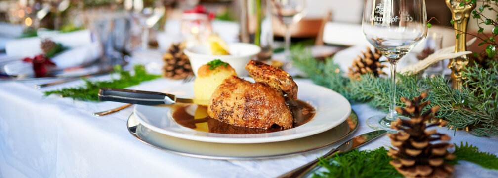 Gegrillte Ente zu Weihnachten an einem festlich gedeckten Tisch und mit reichlich Deko geschm&uuml;ckt