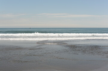 Picturesque seashore with beach and ocean waves and horizon on a sunny day with clear blue sky and calm ocean in Hokkaido, northern Japan, Asia