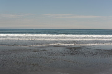 Picturesque seashore with beach and ocean waves and horizon on a sunny day with clear blue sky and calm ocean in Hokkaido, northern Japan, Asia